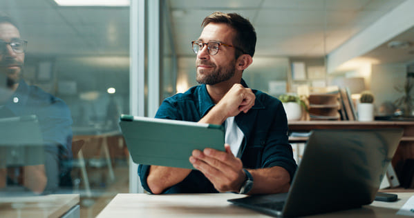 A man in a office holding a tablet device