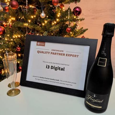 A framed certificate and bottle of sparkling wine on a table