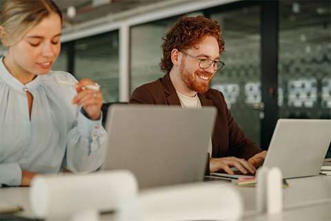 A woman and man working at a workstation