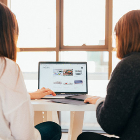 Two people working on a laptop