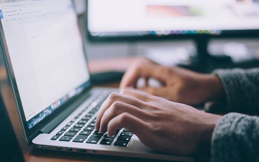 A Person Typing On A Laptop (900X563)