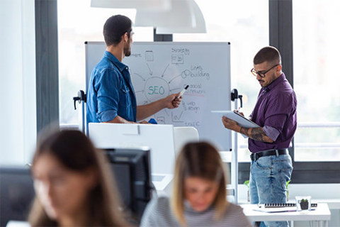 Two people working on a whiteboard