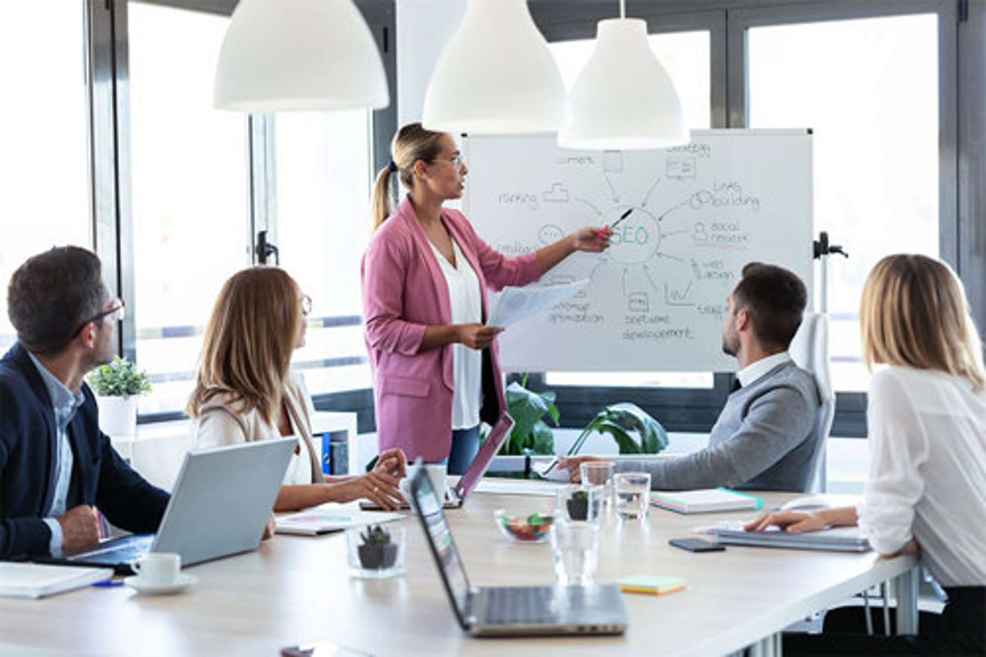 A woman working on a whiteboard in a meeting