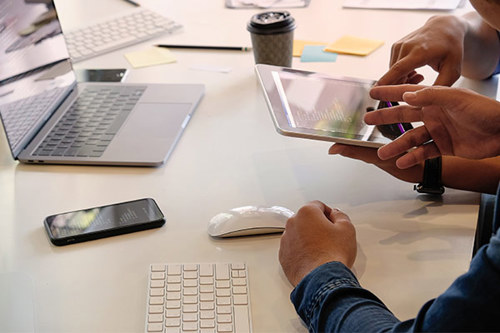 Two People Working On Multiple Devices