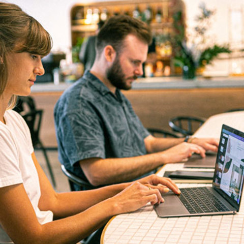 Two people working on laptops