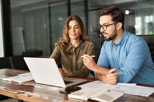 Two People In A Meeting Working On A Laptop