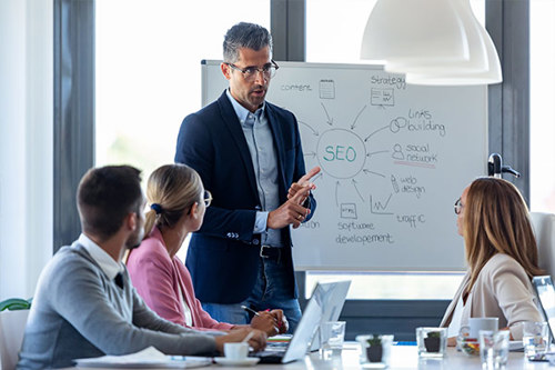 A Group Of People Talking In A Meeting