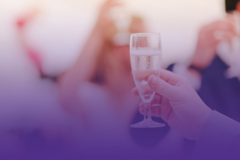 A person raising a glass of sparkling wine