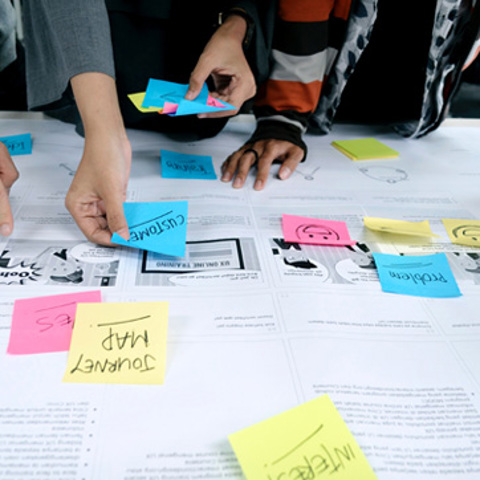 People working with sticky notes on a board